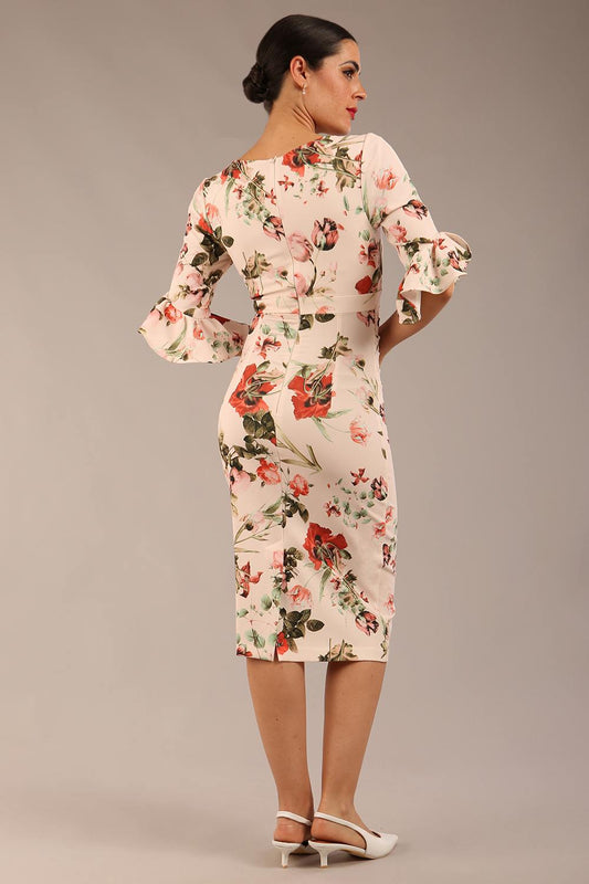 brunette model is wearing a diva catwalk hollie print pencil dress with 3/4 sleeves and frill details v neckline and knee length in rose blush print front image