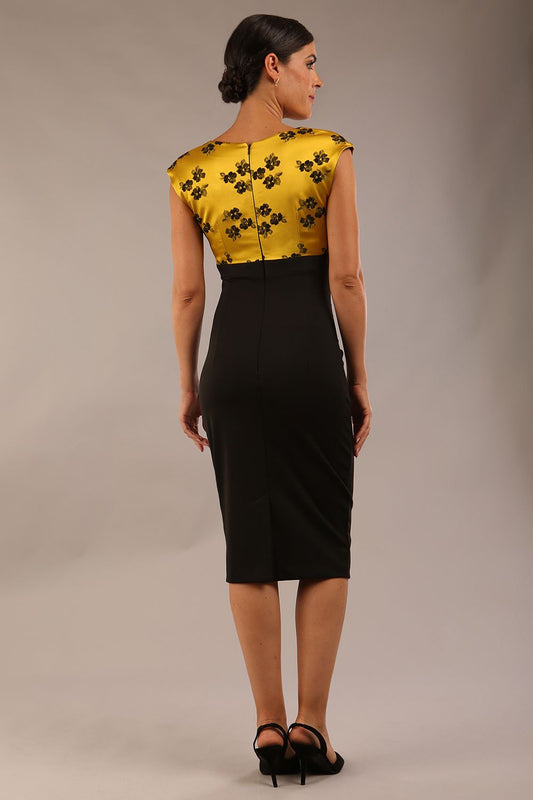 brunette model wearing diva catwalk dresses from england nadia colour block in black and gold colours sleeveless dress front