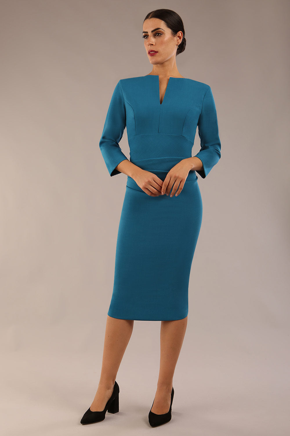 model is wearing diva catwalk chandos sheath dress with three quarter sleeve and slit in the middle of the neckline in teal front