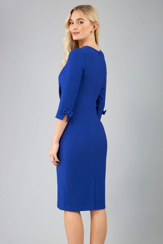 blonde model is wearing diva catwalk logan round neck sleeved pencil dress with side arrow pleating detail in royal blue front