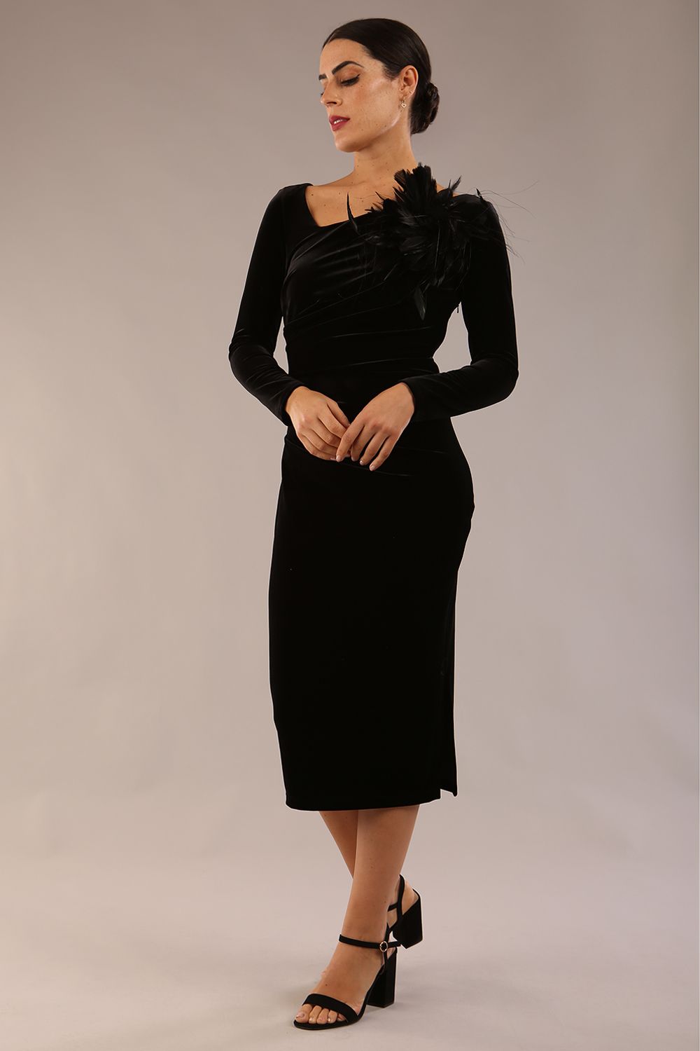 model is wearing a diva catwalk Renoir Long Sleeve Velvet Dress long sleeves midi length with side vent and asymmetric neckline and pleating details in black velvet