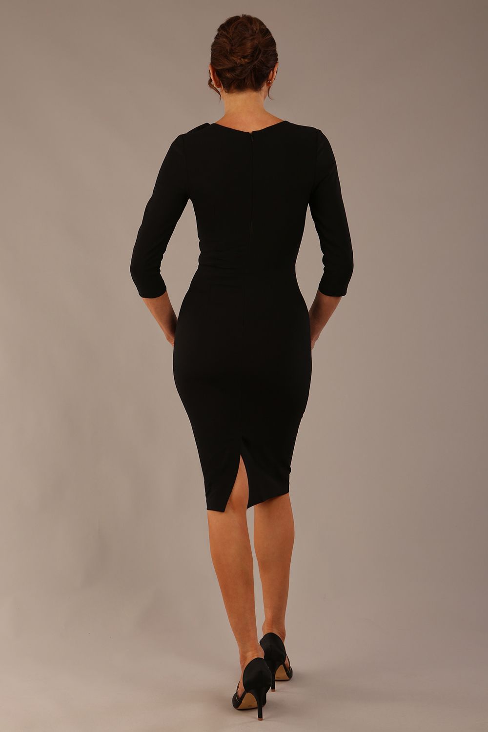 brunette model is wearing a diva catwalk Mirabelle ¾ Sleeves & Floral Shoulder Detail Pencil Dress with diagonal pleating across the front knee length in black colour front image