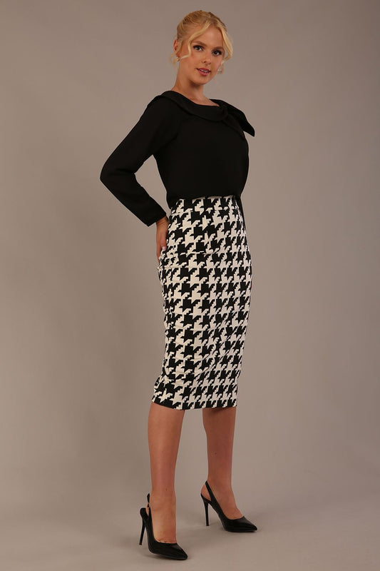 Woman sitting on a chair wearing a diva catwalk cressida black top and houndstooth-patterned skirt against a plain background (Houndstooth print)