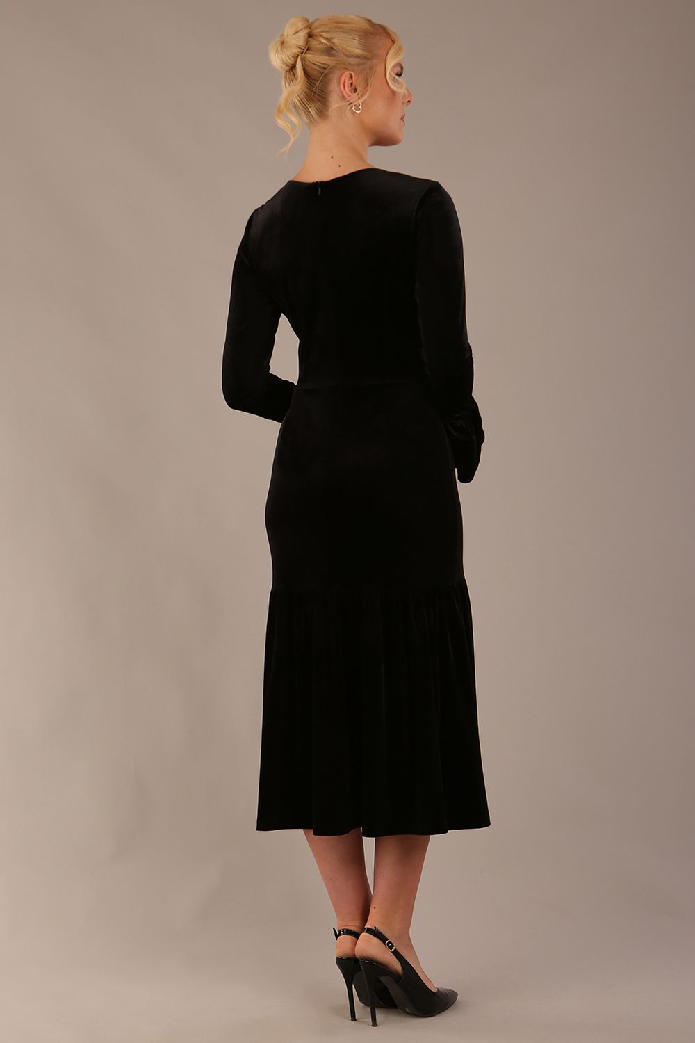 Model wearing the Sophisticat fluted sleeve velvet dress in black (Black Velvet)