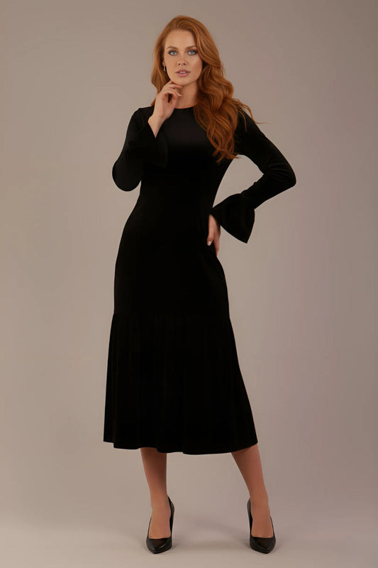 Model wearing the Sophisticat fluted sleeve velvet dress in black (Black Velvet)