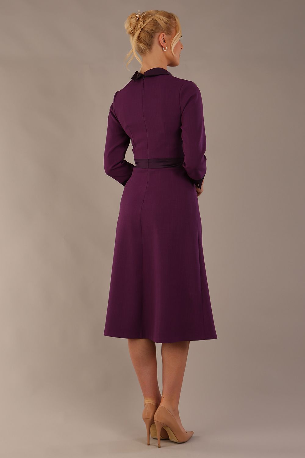 Model wearing the Sybil A-line midi dress in imperial purple with a satin cowl neck and waistband. (Imperial Purple)