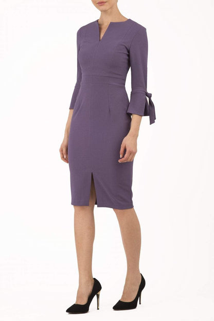 blonde model wearing diva catwalk zoe 3 4 sleeve formal dress with a split rounded neckline and split on skirt in opulent mauve front