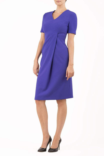 brunette model wearing diva catwalk tregony a-line dress with lowered v-neckline in spectrum indigo and short sleeves front
