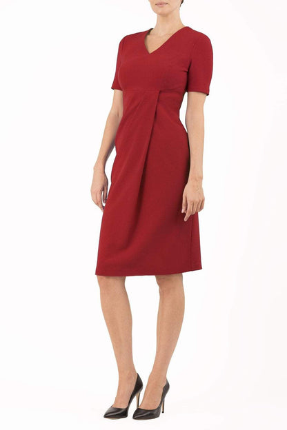 brunette model wearing diva catwalk tregony a-line dress with lowered v-neckline in passion red and short sleeves front