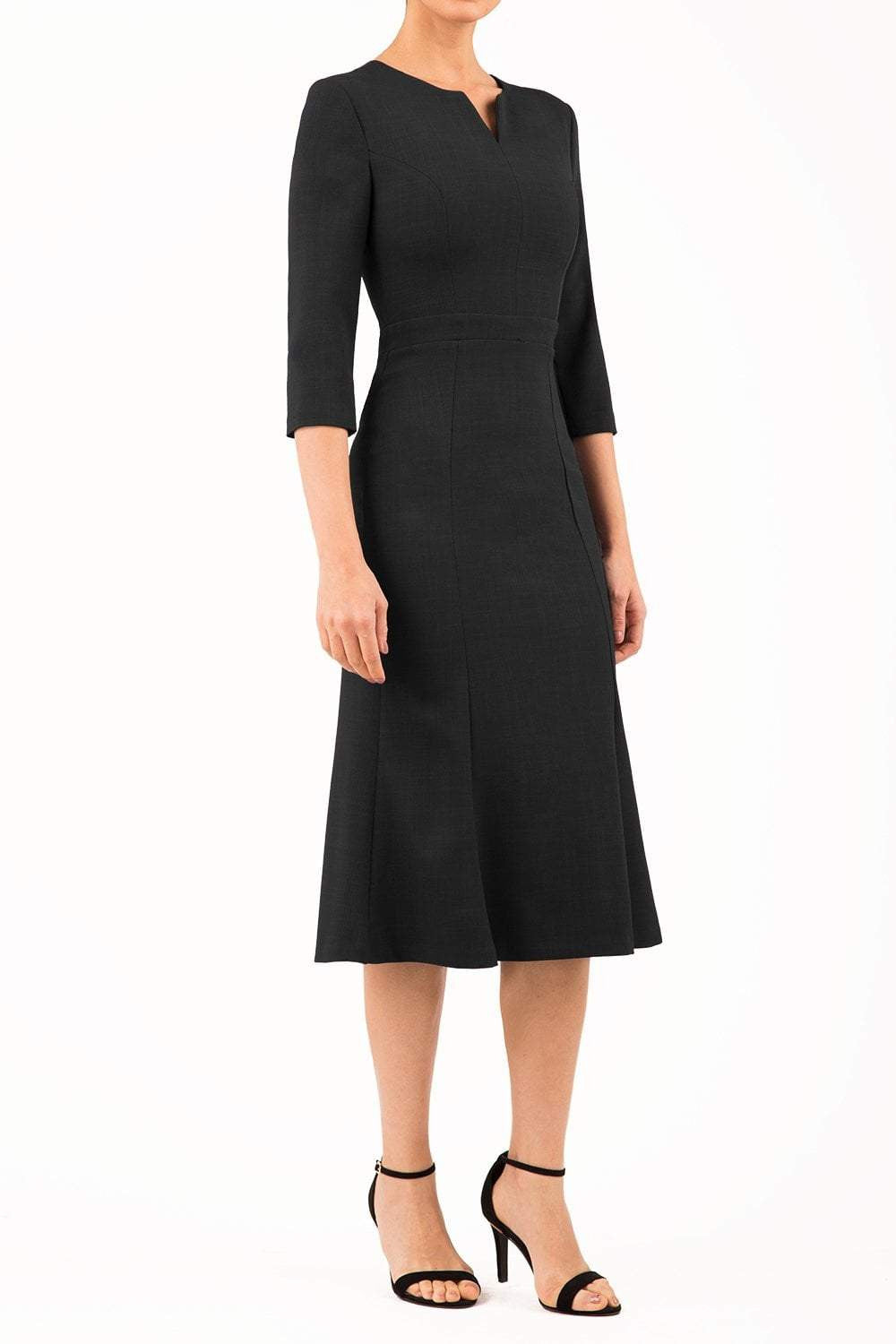 blonde model is wearing diva catwalk senne midaxi sleeved dress with fishtail and rounded neckline with a slit in the middle in black front