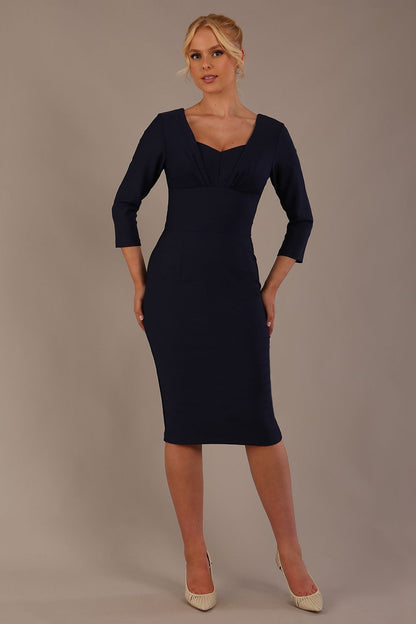 Woman wearing a diva catwalk Seed Greenwich Sleeved Pencil Dress in navy blue colour with a plain background