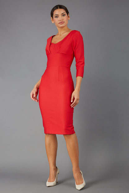 Woman wearing a diva catwalk salsa red Seed Greenwich Sleeved Pencil Dress with a plain background