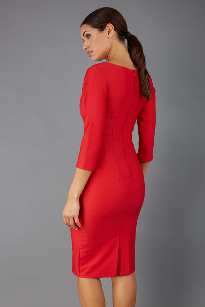 Woman wearing a diva catwalk salsa red Seed Greenwich Sleeved Pencil Dress with a plain background