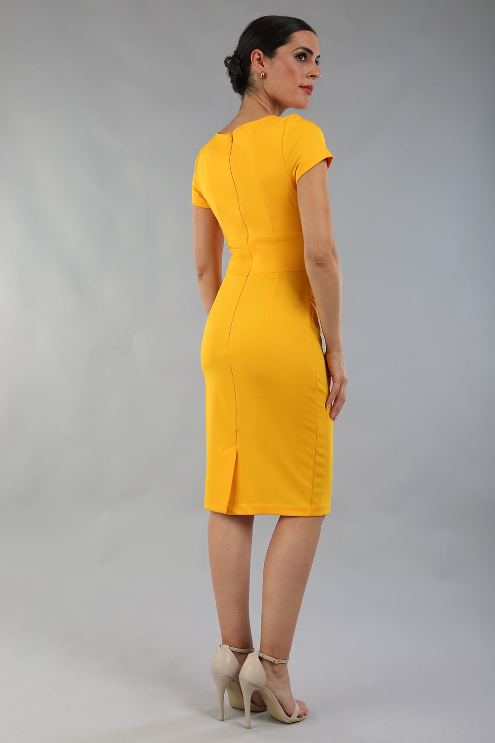 Model wearing Diva Catwalk Donna Short Sleeve Pencil Dress with a wide band and pleating across the tummy area in Saffron Yellow  front