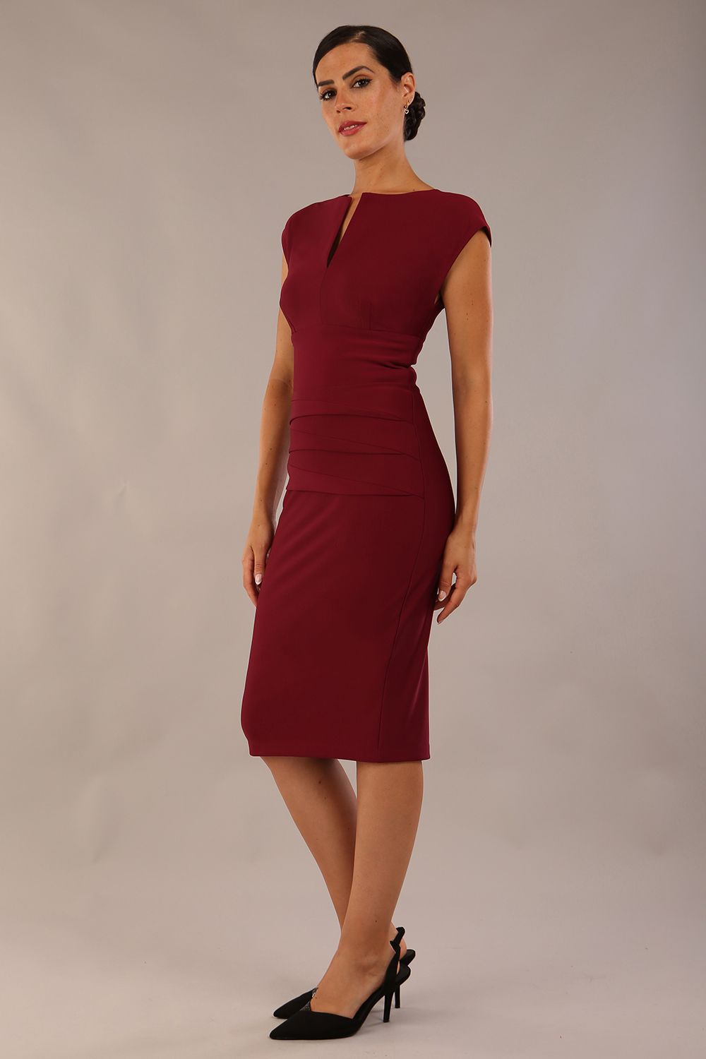 model wearing diva catwalk daphne sleeveless pencil dress with rounded neckline with split in the middle in blissful burgundy side