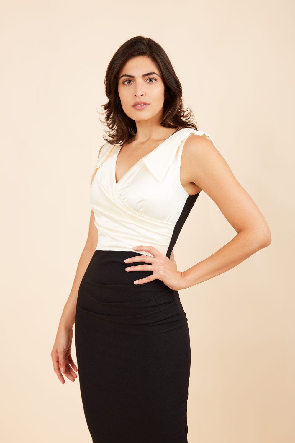 Model wearing the Diva Broadway Satin dress with satin bodice to front and pleating at the front in black and gardenia cream front image