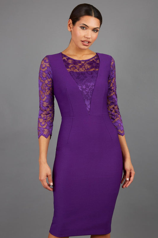 Brunette Model is wearing a seed couture lace pencil dress by diva catwalk in purple front