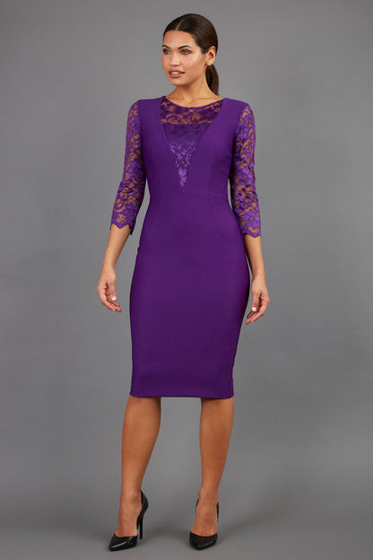 Brunette Model is wearing a seed couture lace pencil dress by diva catwalk in purple front