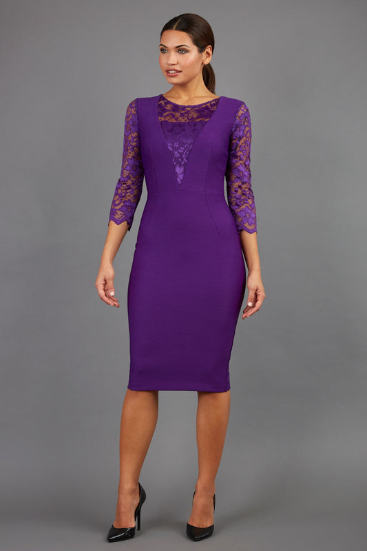 Brunette Model is wearing a seed couture lace pencil dress by diva catwalk in purple front