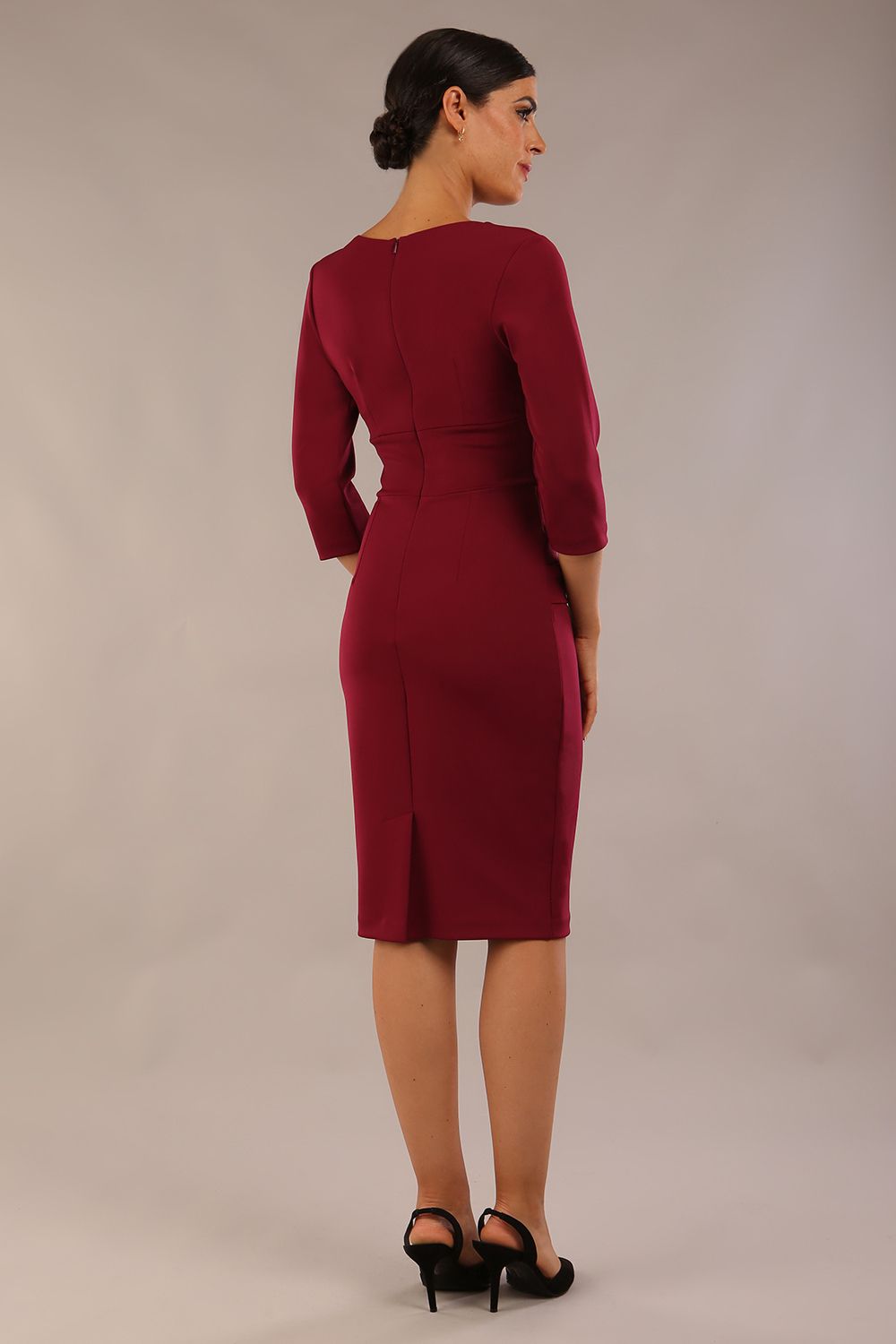 Model wearing the Diva Daphne ¾ Sleeved dress with pleat detail across the hips and ¾ sleeve length in blissful burgundy front