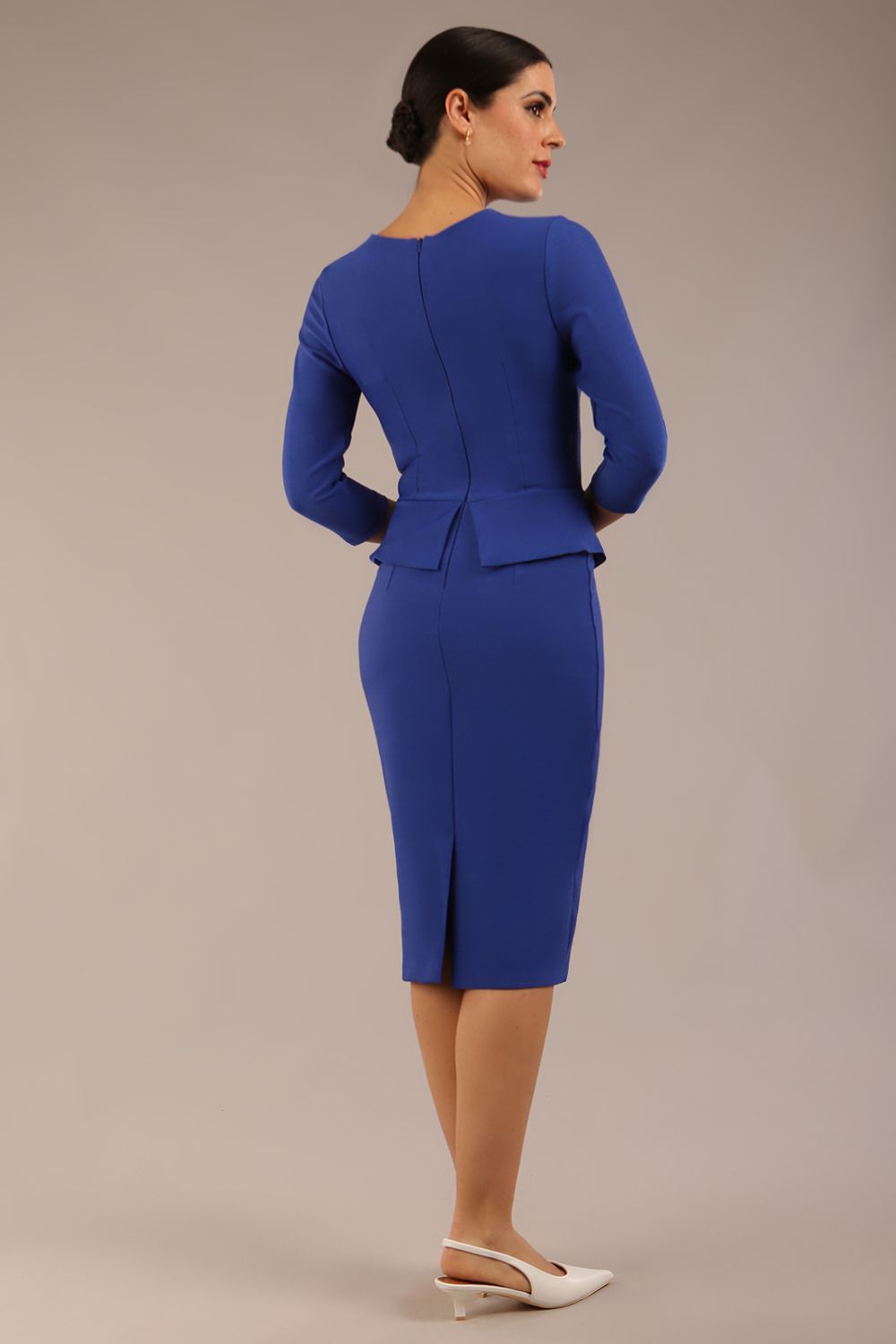Brunette Model is wearing a three quarter sleeve couture seed pencil dress frill side detail by Diva Catwalk in monaco blue