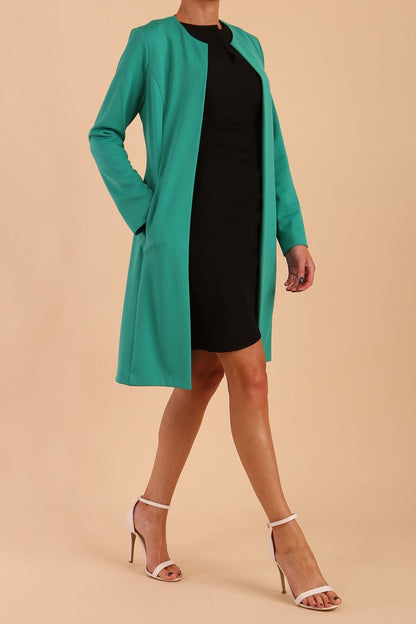 model wearing diva catwalk teal coat with long sleeves and a belt in Emerald Green side