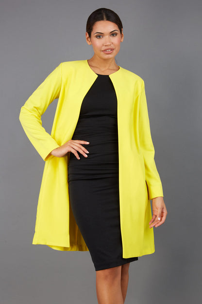 model wearing diva catwalk yellow coat with long sleeves and a belt front