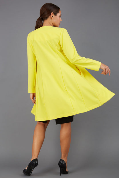 model wearing diva catwalk yellow coat with long sleeves and a belt front
