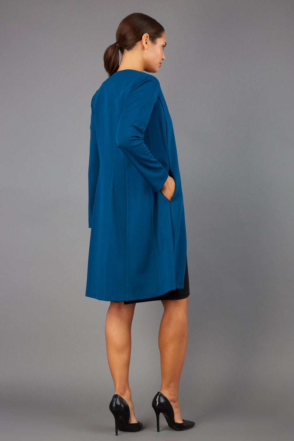 model wearing diva catwalk teal coat with long sleeves and a belt front