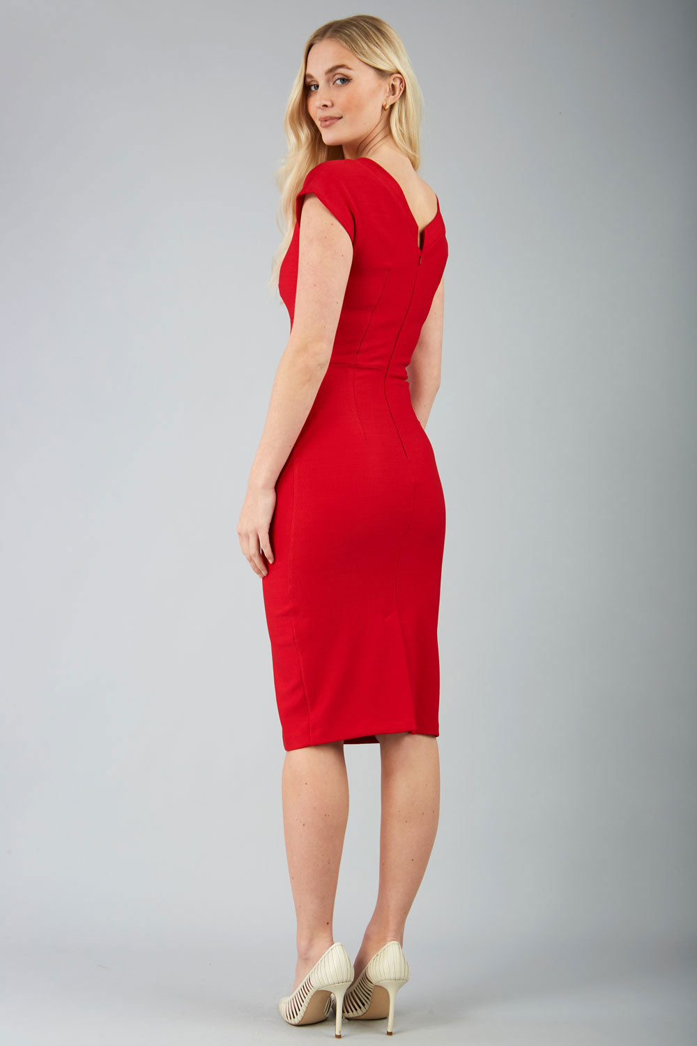 A model wearing a red, short-sleeved, knee-length pencil dress with a round neckline and pleating detail across the front.