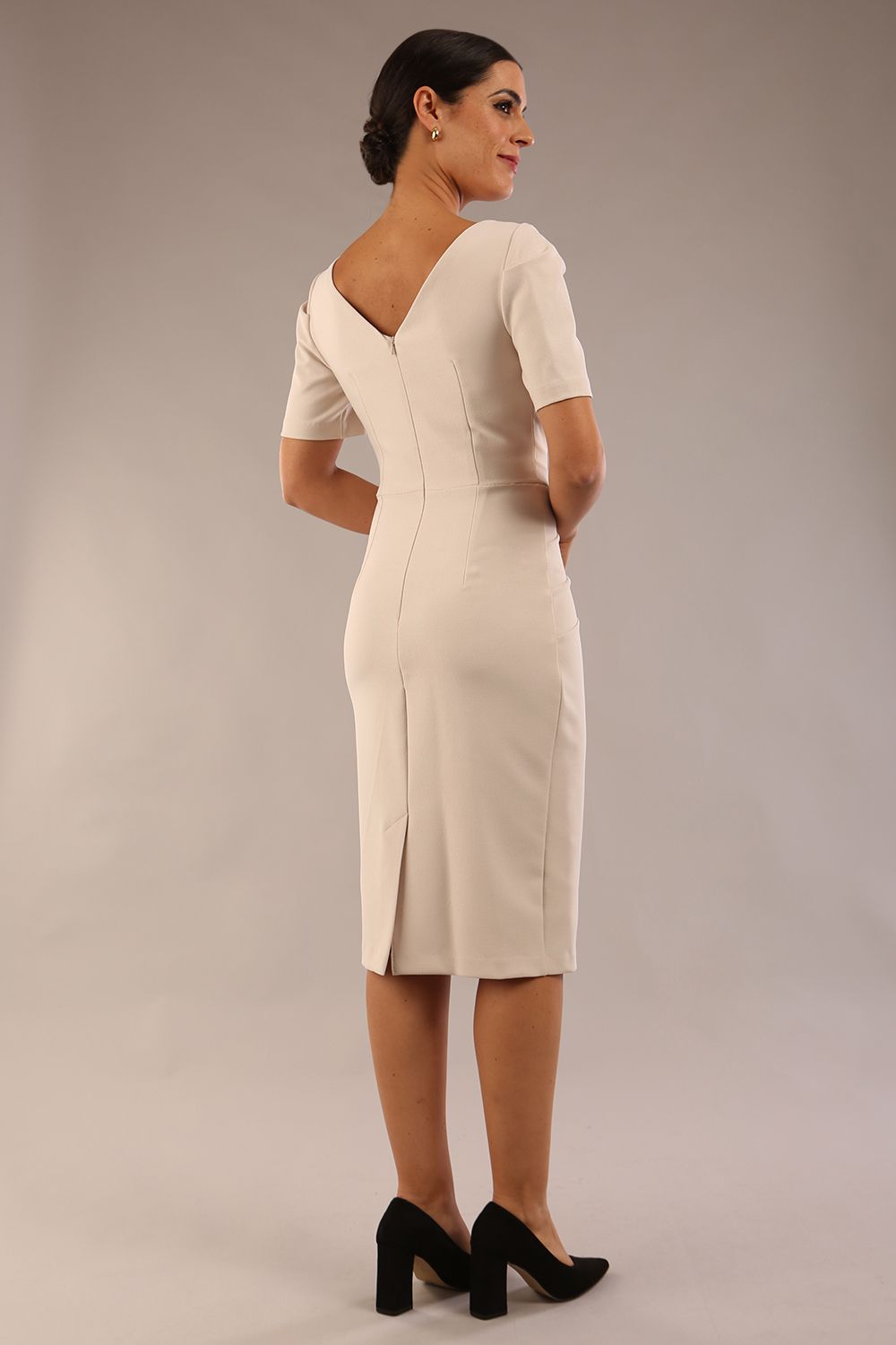 model is wearing diva catwalk seed charlotte pencil plain dress with short sleeve and pleated detail on shoulder in sandy cream front