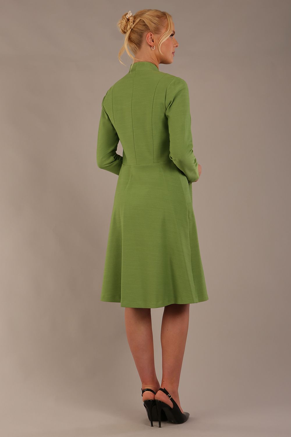blonde model wearing diva catwalk couture fine raquella coat with buttons across the front and long sleeves with high neck and pockets in citrus green colour front (Citrus Green)