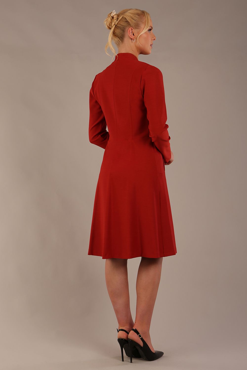 blonde model wearing diva catwalk couture fine raquella coat with buttons across the front and long sleeves with high neck and pockets in garnet red colour front (Garnet Red)
