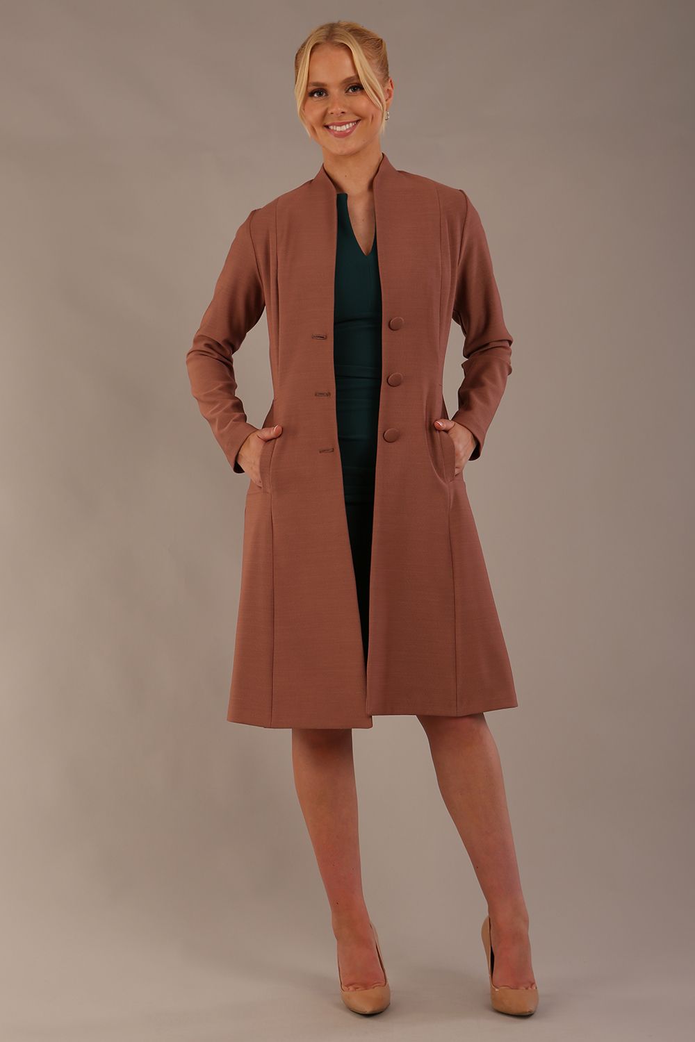 model wearing diva catwalk couture fine raquella coat with buttons across the front and long sleeves with high neck and pockets in acorn brown colour side (Acorn Brown)