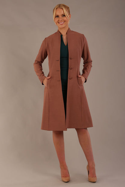 model wearing diva catwalk couture fine raquella coat with buttons across the front and long sleeves with high neck and pockets in acorn brown colour side (Acorn Brown)