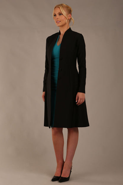 model wearing diva catwalk couture fine raquella coat with buttons across the front and long sleeves with high neck and pockets in black colour front (Black)