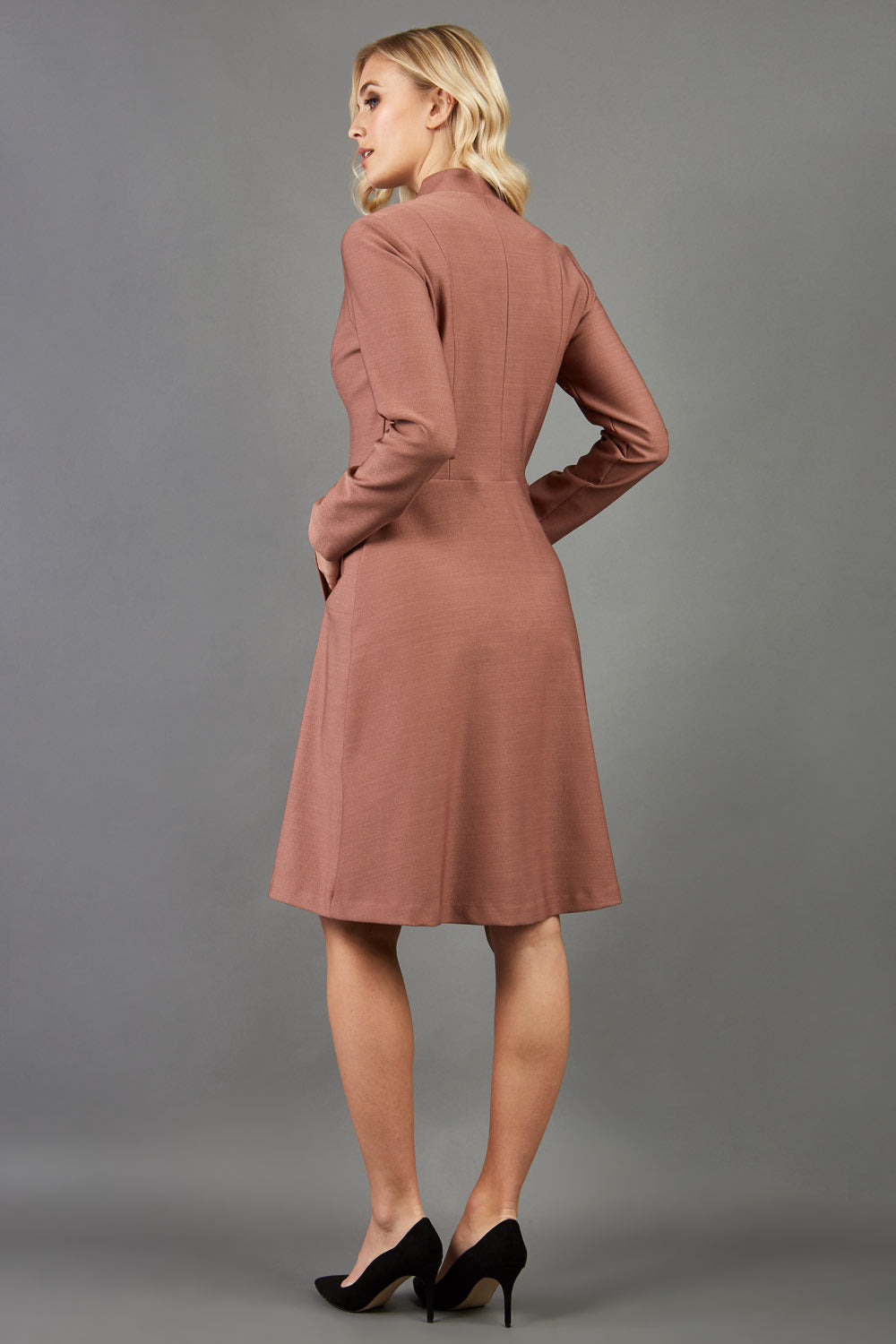 model wearing diva catwalk couture fine raquella coat with buttons across the front and long sleeves with high neck and pockets in acorn brown colour back