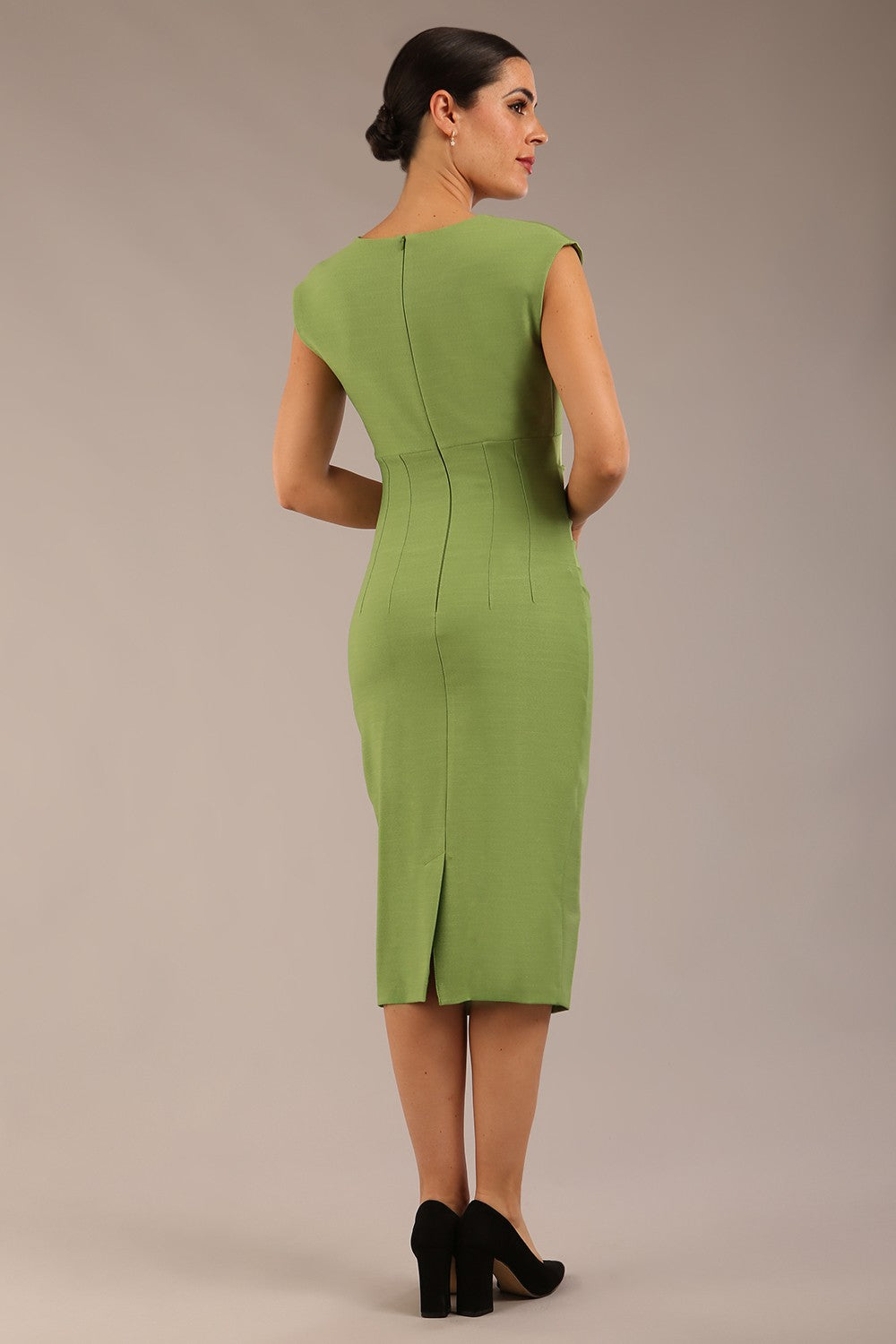 brunette model is wearing a diva catwalk seed Fitzrovia sleeveless pencil dress with round neckline and v-slit and knee length in citrus green colour front image