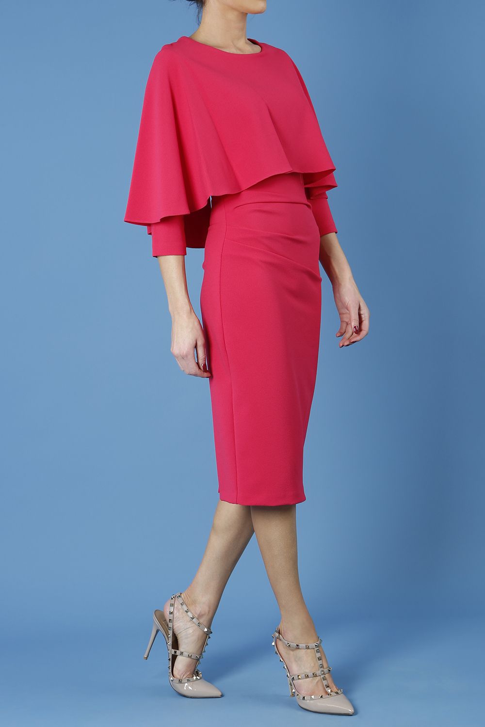 model wearing diva catwalk lizanne pencil-skirt dress with an attached wide cape detail and 3 4 sleeves in colour honeysuckle pink back