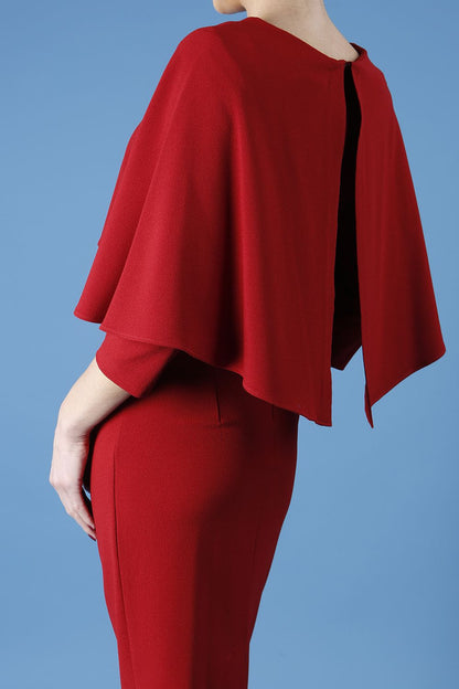 model wearing diva catwalk lizanne pencil-skirt dress with an attached wide cape detail and 3 4 sleeves in colour rosewood red front