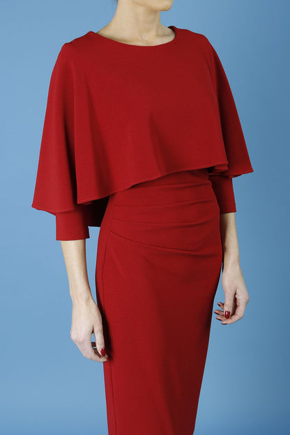 model wearing diva catwalk lizanne pencil-skirt dress with an attached wide cape detail and 3 4 sleeves in colour rosewood red front