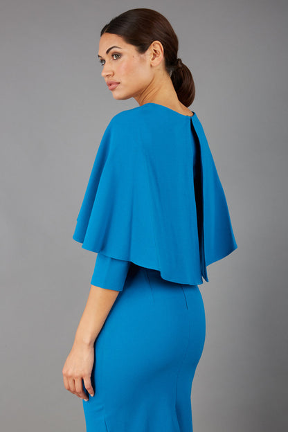 model wearing diva catwalk lizanne pencil-skirt dress with an attached wide cape detail and 3 4 sleeves in colour tropical teal front