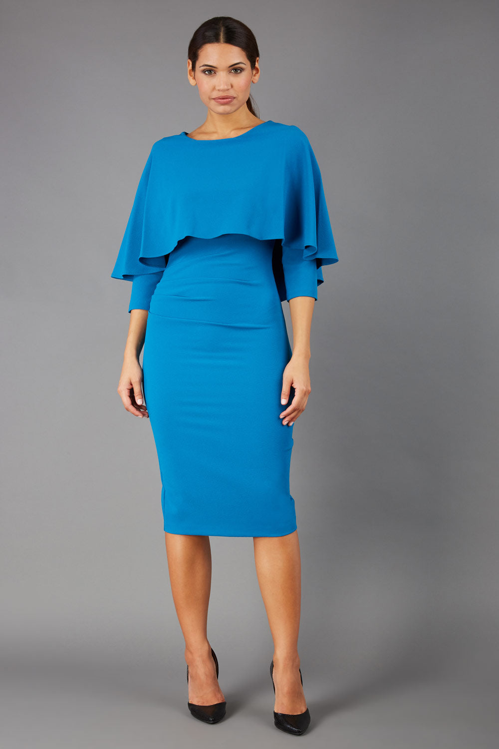 model wearing diva catwalk lizanne pencil-skirt dress with an attached wide cape detail and 3 4 sleeves in colour tropical teal front