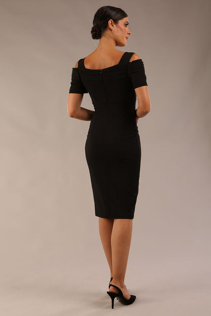 brunette model wearing diva catwalk amorette pencil skirt dress with a cold shoulder detaul and pleating across the bust and slit on a side of skirt in black front