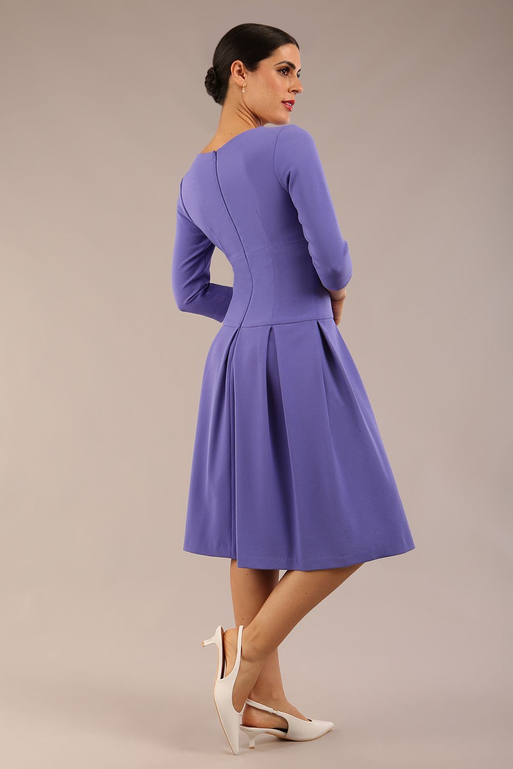 brunette model wearing a diva catwalk malinda swing dress with 3/4 sleeves and knee length and wide waistband in ripple crepe fabric in fusion indigo colour back side image