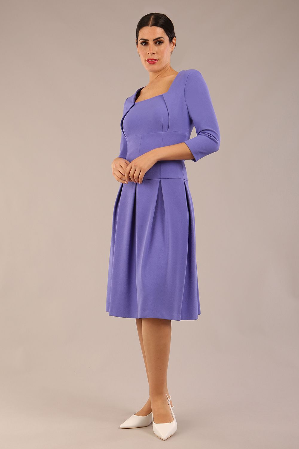 brunette model wearing a diva catwalk malinda swing dress with 3/4 sleeves and knee length and wide waistband in ripple crepe fabric in fusion indigo colour back side image