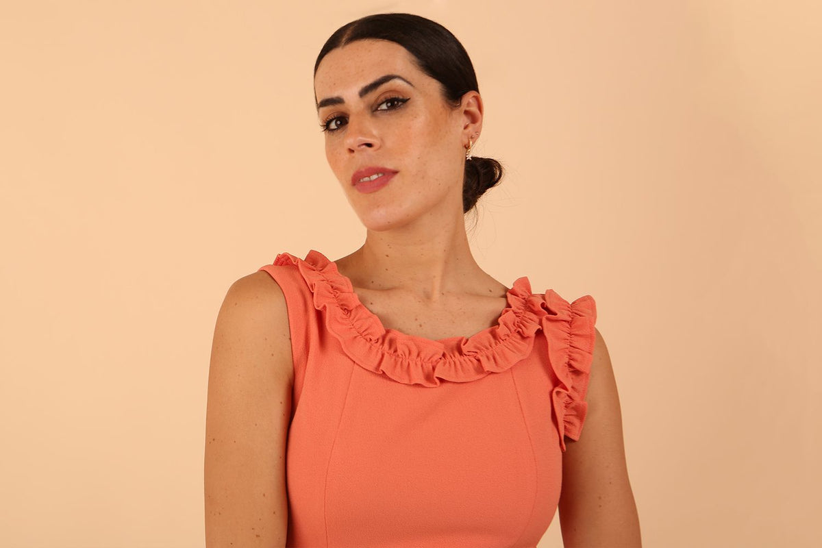 brunette model is wearing diva catwalk odessa pencil sleeveless dress with frill detail on rounded neckline in Dusty coral front
