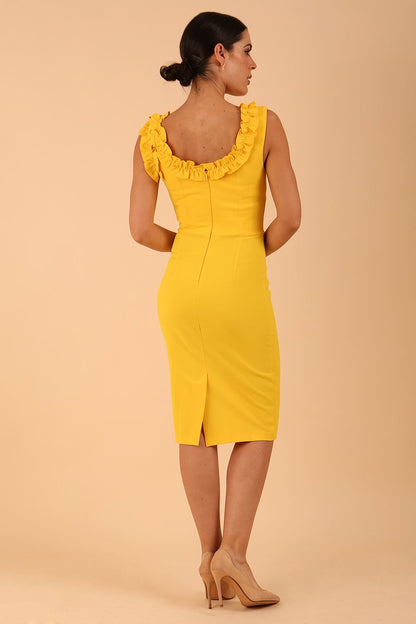 brunette model is wearing diva catwalk odessa pencil sleeveless dress with frill detail on rounded neckline in freesia yellow front