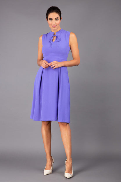 brunette model wearing diva catwalk oceana a-line swing skirt sleeveless dress with funnel neckline and tie detail in lilac purple front