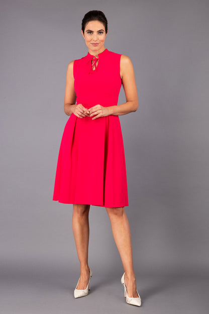 brunette model wearing diva catwalk oceana a-line swing skirt sleeveless dress with funnel neckline and tie detail in pink back